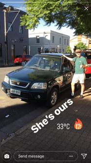 A backpacker standing beside a newly bought green Honda CR-V